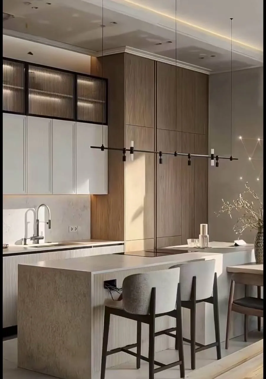 Fluted Island Kitchen with Reeded-Glass Uppers — after — Kitchen island and cabinetry mid-install on bare floor, then finished fluted island, reeded-glass uppers, and stone tops.